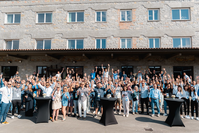 Large group photo of Dynamics Minds 2024 attendees in front of the venue.